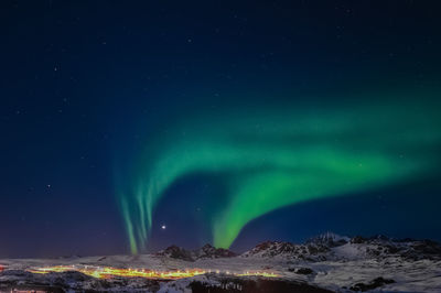 Scenic view of snowcapped mountains against sky at night