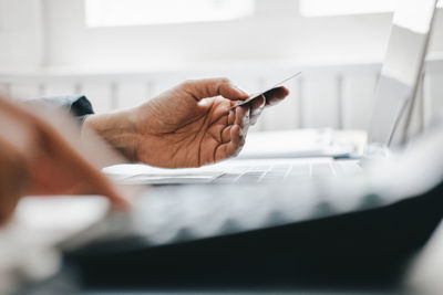 Cropped image of man holding hands on table