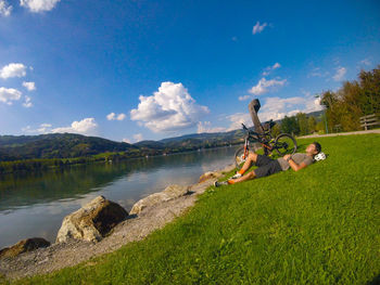 People on lake against sky