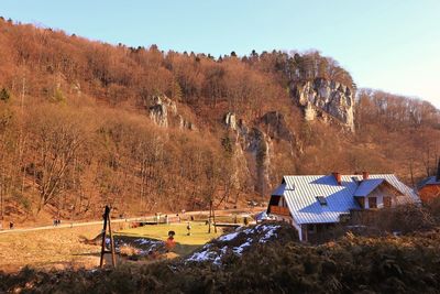 Houses and trees on landscape against sky