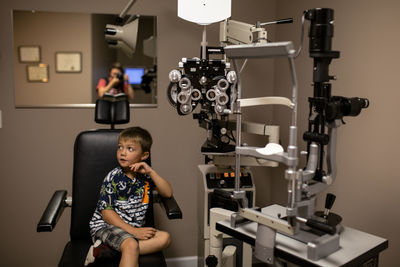 Young boy nervous at the eye doctor with mother