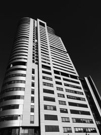 Low angle view of skyscraper against clear sky at night