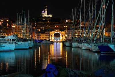 Boats moored at old port of montreal in illuminated city