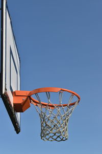 Low angle view of basketball hoop against clear blue sky