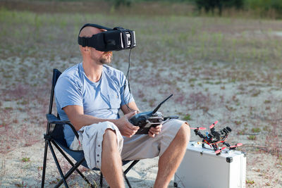 Man using virtual headset while sitting outdoors