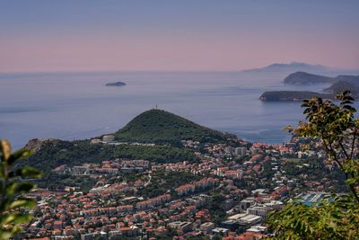 High angle view of townscape by sea against sky
