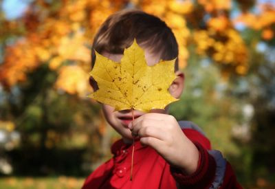 Close-up of hand holding autumn leaf