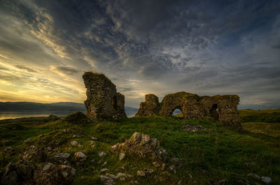 Stone wall against sky during sunset