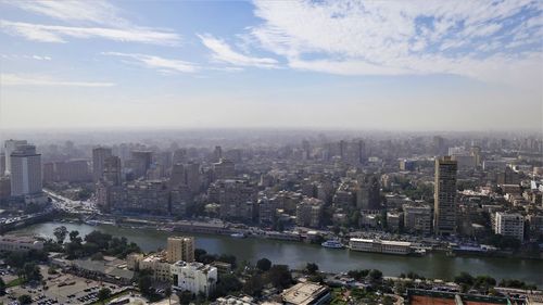 High angle view of river amidst buildings in city against sky