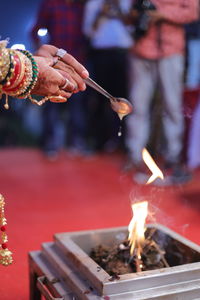 Midsection of man holding burning candles