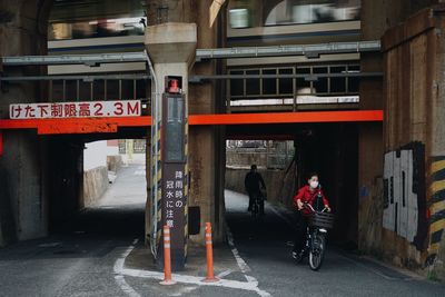 People riding bicycle on road in city