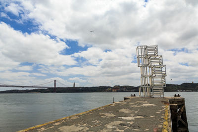 View of bridge over river against cloudy sky