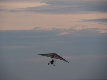 Silhouette of people hang gliding against sky