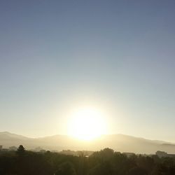 Scenic view of mountains against clear sky at sunset