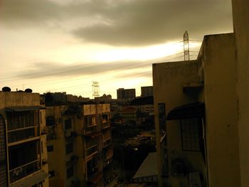 Buildings in city against cloudy sky