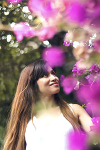 Woman standing by pink flowering plants