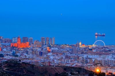 Buildings by sea at dusk in city