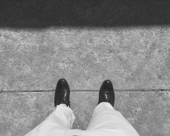 Low section of man standing on tiled floor