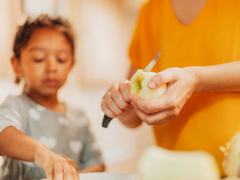 Mother at home preparing apple crisp with her young daughter