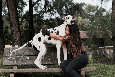 Woman hugging big dog on park bench