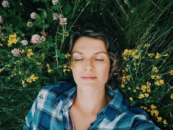 Portrait of young woman lying down on plant