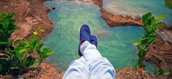 Low section of man relaxing on shore