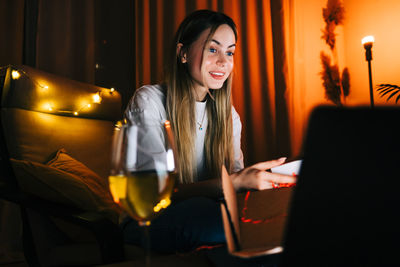 Young woman using phone while sitting on table