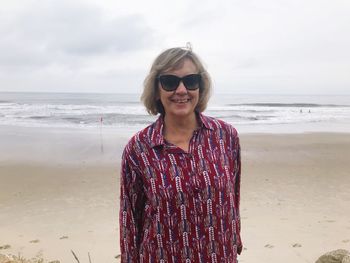 Portrait of smiling young woman standing on beach