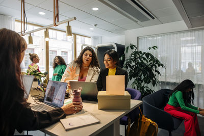 Multiracial female entrepreneurs discussing while working at office