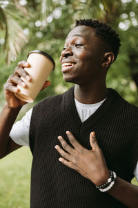 Young african american man with to go coffee cup on street outdoor
