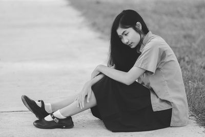 Side view of young woman sitting outdoors
