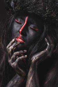 Woman with body paint against black background