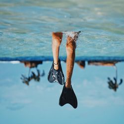 Low section of man in sea against sky