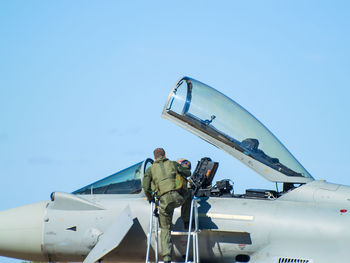 Low angle view of airplane on airport runway against clear sky