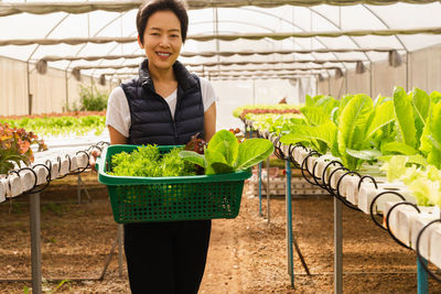 Portrait of woman holding potted plants