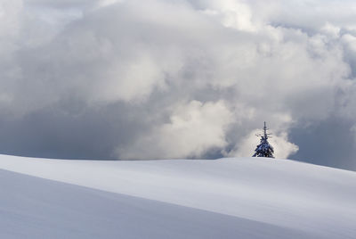 Windmill on snow covered mountain against sky in rodnei mountains 