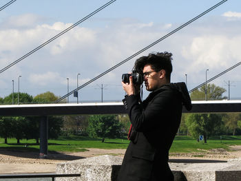 Man photographing against sky