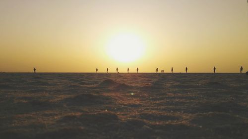 Scenic view of beach against clear sky during sunset