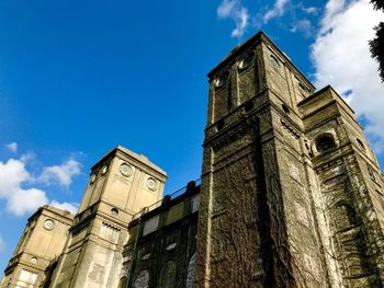Low angle view of clock tower against blue sky