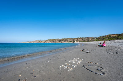 Scenic view of beach against clear blue sky