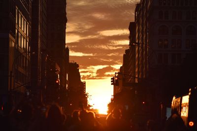 Panoramic view of people in city against sky during sunset