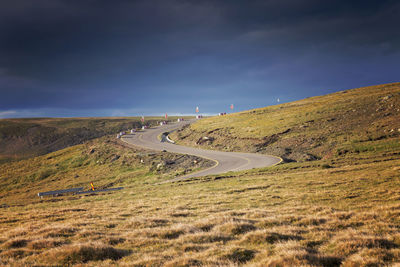 Scenic view of road by mountain against sky