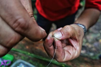 Low section of man preparing fishing tackle