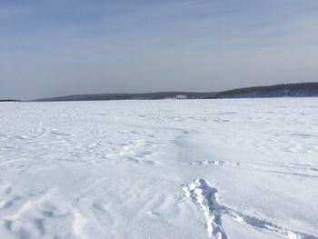 Scenic view of snow covered land against sky