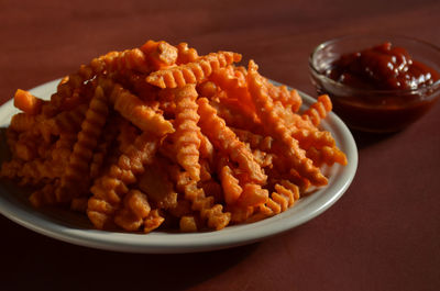 Close-up of sweet potato french fries with ketchup on table