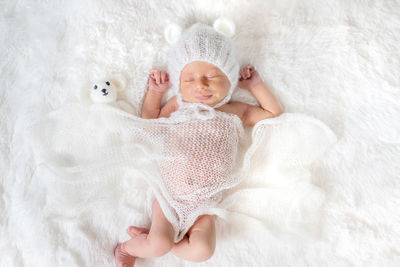 Cute baby girl lying on bed at home