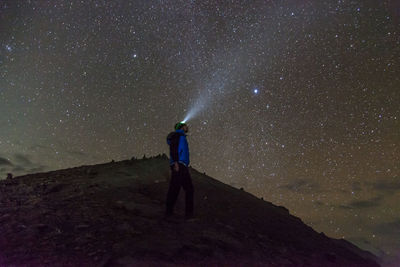Low angle view of man with headlamp while standing on annapurna mountain against star field at night