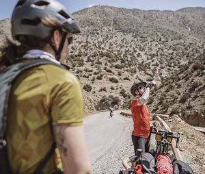 Male cyclist drinks from his water bottle while biking through morocco