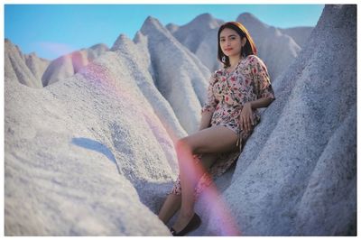 Portrait of woman sitting on rock