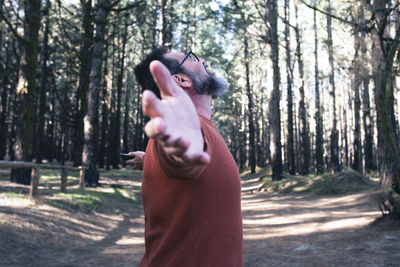 Young woman using mobile phone while standing in forest